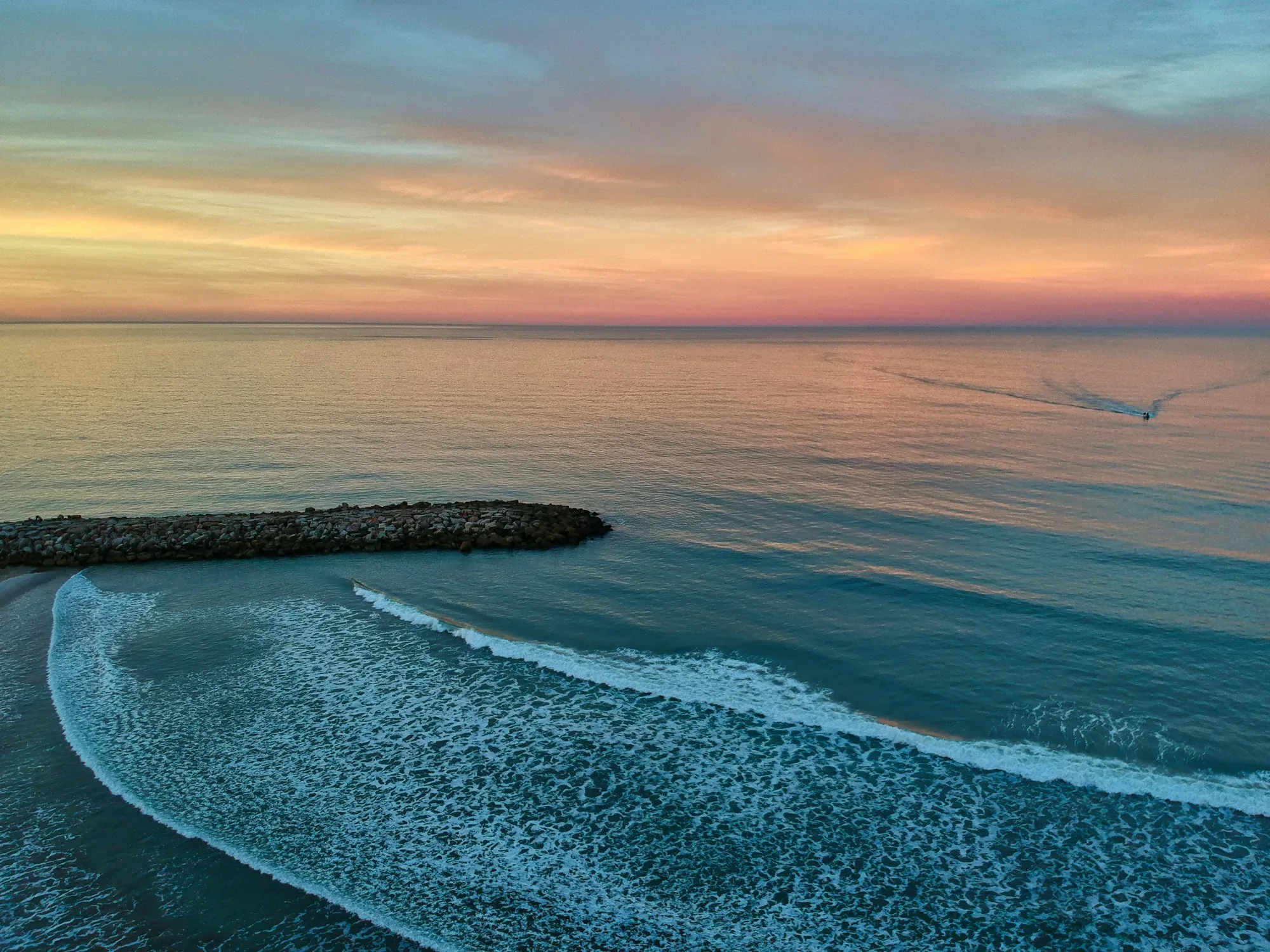 Amanecer sobre el mar y una escollera en Mar del Plata