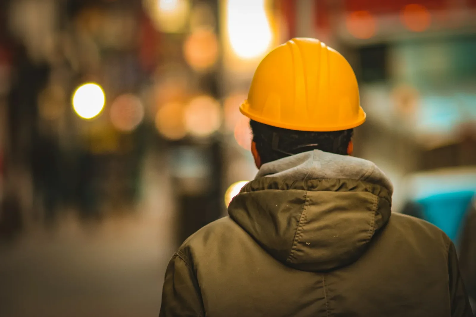 Trabajador de espaldas con casco amarillo